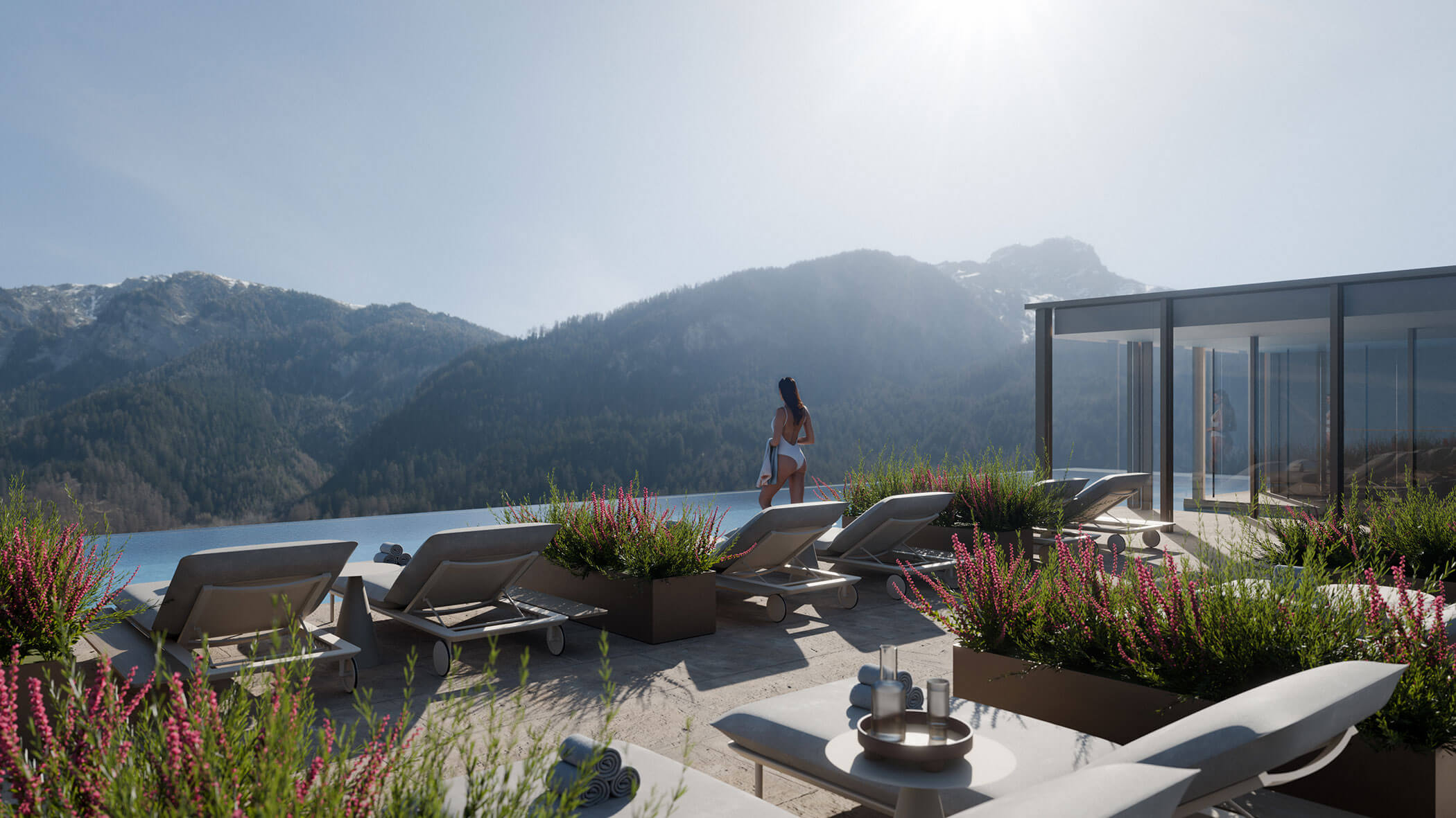 Eine Frau steht an einem Außenpool mit Liegestühlen und blickt auf die Berge unter einem klaren Himmel. - Majestic Resorts (Relaunch)