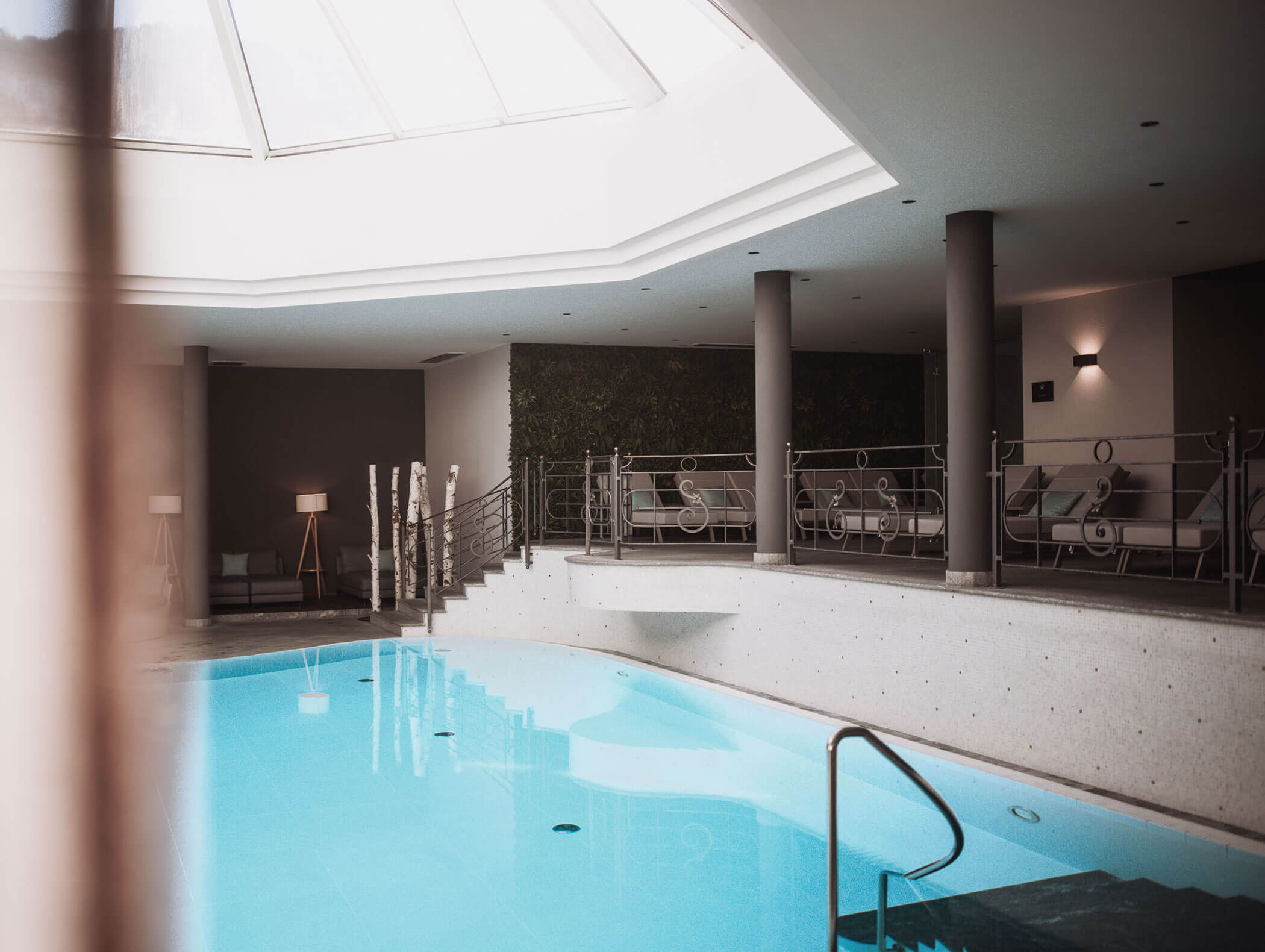 Hallenbad mit Oberlicht, Liegestühlen und modernem Dekor in einer entspannenden Spa-Umgebung. - Majestic Resorts (Relaunch)